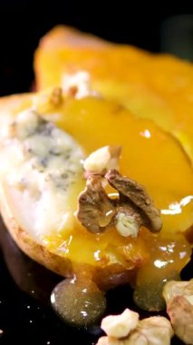 Yavaş çekimde armut ve peynirden oluşan bir tatlı akıntısı üzerine dökülür. Yemek pişirme konsepti. Meyveli tatlı. Dikey görüntü. Yüksek kalite 4k görüntü