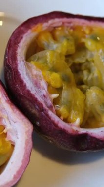 Yarım yamalak çarkıfelek meyvesi alan bir elin yavaş çekim sahnesi. Yüksek kalite 4k görüntü