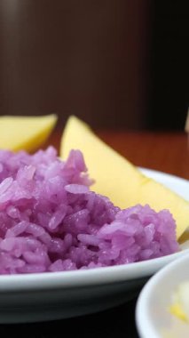 Fıstık ezmesi karışımı, mor pilav ve doğulu mango parçaları. Üzerine hindistan cevizi sütü serpilmiş pilav ve kavrulmuş fıstık. Tabakta servis edilen mangolu pilav. Sonraki yer mango.