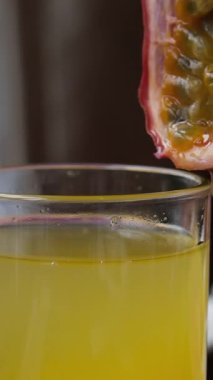 Çarkıfelek meyvesi tutku meyveli kokteyline düşer. Yavaş çekim videosu. Yüksek kalite 4k görüntü