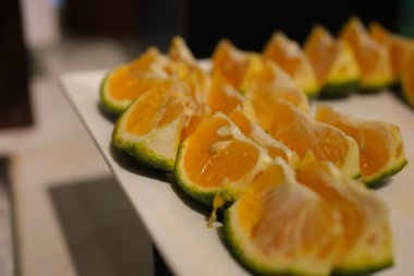 Beyaza izole edilmiş sulu portakal dilimleri. yeşil Vietnam mandalinası