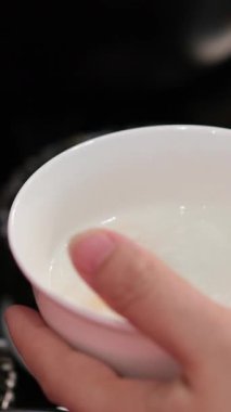 Bir kaşık dolusu pirincin kaynayan pirinç lapasından çalındığı yakın çekim. Bu çekim pilavın dokusunu ve pişirme sürecini vurgular. Yüksek kalite 4k görüntü