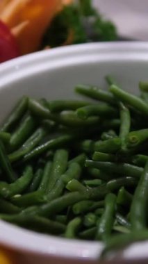 Beyaz ahşap bir masada kasede taze yeşil fasulye, üst manzara. Yüksek kalite fotoğraf