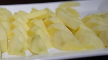 Olgun sarı mango eti, pürüzlü dilimler, beyaz bir tabağa yerleştirilmiş çok renkli bir arka plan. Yüksek kalite fotoğraf
