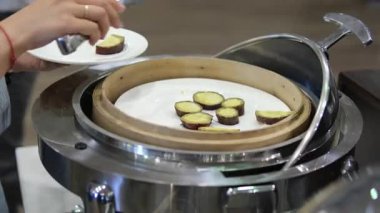 Tatlı patates büfesi dilimi ve ahşap açık büfe adam tatlı patates yuca kökü seçiyor. Yüksek kalite 4k görüntü