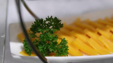 Güzel bir tabak Tayland mangolu yapışkan pirinç. Tatlı, olgun mango dilimleri sanatsal olarak düzenlenir. Canlı, mavi, yapışkan pirinç üzerinde, susam tohumlarıyla süslenmiş, küçük sarı bir çiçek.