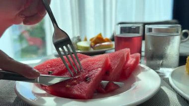 İnsan eli porselen tabakta çatalla karpuz alıyor. Yüksek kalite 4k görüntü