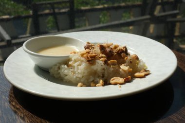 Üzerine fıstık serpiştirilmiş, beyaz tabakta yapış yapış pirinç konserve süt Vietnam tatlısı. Yüksek kalite fotoğraf