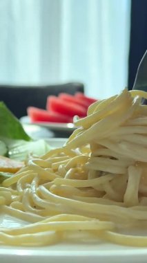 Spagetti makarnalı kıvrımlı çatal ve yakın dövüş. Yüksek kalite 4k görüntü