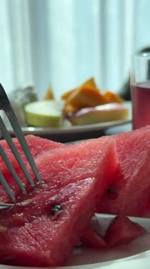 İnsan eli porselen tabakta çatalla karpuz alıyor. Yüksek kalite 4k görüntü