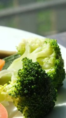 Beyaz tabaktan brokoli, sağlıklı beslenme düzeni. Pişene kadar brokoli kaynatın. Yüksek kalite 4k görüntü