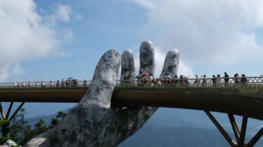 Ba Na Hills 'teki Altın Köprü, Vietnam, Ba Na Hills' deki ikonik Altın Köprü, zarif bir şekilde dev taş ellerle tutuluyor, bereketli dağların nefes kesici manzarasını sunuyor. Da Nang, Vietnam 21.05.2025