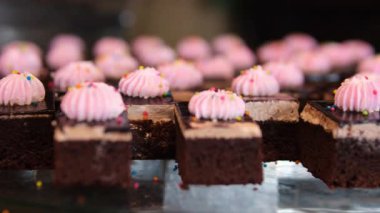 Yeni pişmiş browni küplerinin yakın çekim videosu, parçalanmış kabuklarını ve zengin iç kısımlarını vurguluyor. Dokuya ve bu klasik tedavinin karşı konulmaz cazibesine odaklanıyoruz. Yüksek kalite 4k görüntü