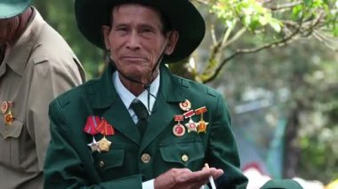 Vietnam Savaşı gazileri, madalyalı ve sigaralı yaşlı adamlar kameraya bakan yaşlı ve üniformalı kahramanlara bakan tipler. Vietnam Danang 05.21.2025 