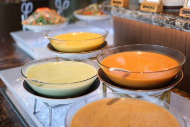 Kremalı mantar çorbasıyla dolu küçük, beyaz kaseler. Her kase kızarmış ekmek ve bir tutam otla süslenmiş. Açık büfe ya da yemek servisi. Yüksek kalite 