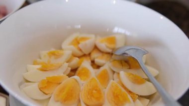 Bir tabak haşlanmış yumurta, bütün ve dilimlenmiş parçalar, tüketime hazır..