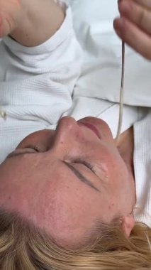 Yatakta beyaz cüppeli yetişkin bir kadın gözlük takıyor. Yaşlılık görüşü düşüyor. Yüksek kalite 4k görüntü