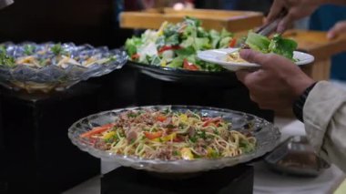 Lüks bir Bali tatil köyü restoranında açık büfe masasında siyah kaselerde servis edilen renkli tropikal salata. Taze sebzeler çok güzel dizilmiş. Yüksek kalite 4k görüntü