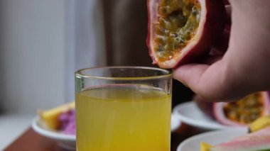 Çarkıfelek meyvesi tutku meyveli kokteyline düşer. Yavaş çekim videosu. Yüksek kalite 4k görüntü