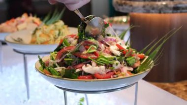 Lüks bir Bali tatil köyü restoranında açık büfe masasında siyah kaselerde servis edilen renkli tropikal salata. Taze sebzeler çok güzel dizilmiş. Yüksek kalite 4k görüntü