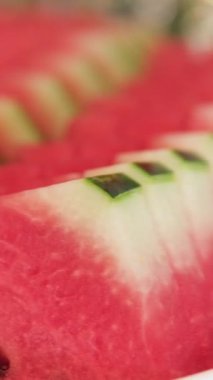 Karpuz dilimleri, sulu kırmızı eti ve taze yeşil kabuğu sergiliyor. Parlak renkler ve doğal dokular sağlıklı yemek severler için mükemmel bir seçim. Dilimlenmiş karpuz tabağı