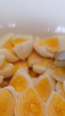 Bir tabak haşlanmış yumurta, bütün ve dilimlenmiş parçalar, tüketime hazır..