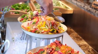 Bir lokantada taze salata, sebze ve tabakla dolu büfeden yemek seçen bir adama yaklaş. Kahvaltıda yemek tercihleri. Yüksek kalite 4k görüntü