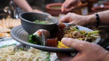 Cruiser 'da büyük bir balık yemeğinin servis edildiği açık büfe sahnesi. Balık, aşındırıcı bir tabağa konmuş sebze ve sosla süslenir. Birisi balıklara maşa veriyor.