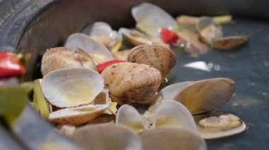 Maydanoz biberli midyeler ve sıcak tavada ahşap çatallı domatesler. Geleneksel İtalyan Akdeniz mutfağı. Yakın plan. Yüksek kalite 4k görüntü