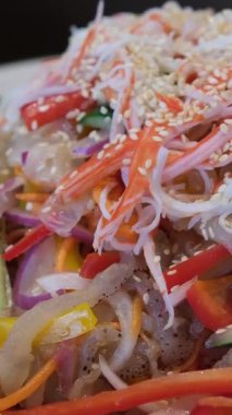 Karidesli, deniz mahsullü, sebzeli, baharatlı ve soya soslu, koyu beton kaplama erişteler. Sebzeli cam mermerli.