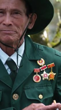 Vietnam Savaşı gazileri, madalyalı ve sigaralı yaşlı adamlar kameraya bakan yaşlı ve üniformalı kahramanlara bakan tipler. Vietnam Danang 05.21.2025 