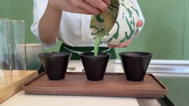 Geleneksel çay seremonisi ortamında ahşap bir tepside sunulan üç kase canlı yeşil kibrit kutusu ile güzel bir eşleşen çay seti. - Evet. Yüksek kalite 4k görüntü