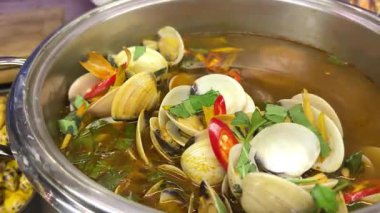 Baharatlı kırmızı sundubu jjigae siyah bir taş kasede, üzerinde yumuşak yumuşak tofu, yeşil sebzeler ve mantarlar var. Taze servis edilmiş, kaseden hala sıcak. Yüksek kalite 4k görüntü