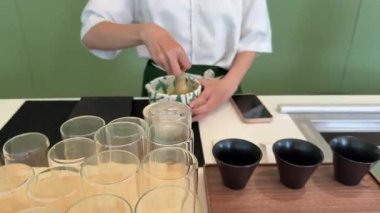 Bir barista matcha hazırlar, barutu pürüzsüz dairesel hareketlerle karıştırır. Yüksek kalite 4k görüntü