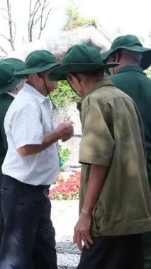 Vietnam Savaşı gazileri, madalyalı ve sigaralı yaşlı adamlar kameraya bakan yaşlı ve üniformalı kahramanlara bakan tipler. Vietnam Danang 05.21.2025 