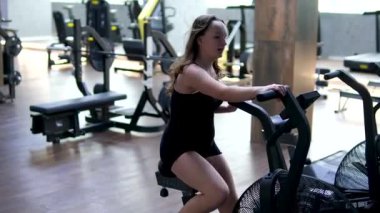 Yakın plan kadın bacak çevirme spor salonunda sabit bisiklet üzerinde pedal çevirme egzersizi. Modern spor aktivitesi, spor, sağlıklı yaşam tarzı konsepti. Bisiklet çeviren atletik kız. görüntüler