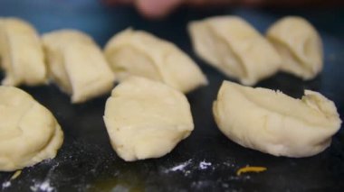 Hamur hazırlama sanatını, geleneksel ekmek yapma ve yemek pişirme zevkleri için ideal, ahşap bir yüzeyde organize edilmiş taze hamur parçalarının çarpıcı görüntüleriyle keşfedin. Yüksek kalite 4k görüntü