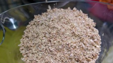 Bademler badem ununun üstüne düşüyor. Ağır çekimde. Cevizleri fındıklı bademlerle doğra et öğütücüsünde kes ve öğüt.