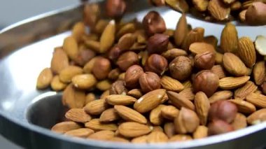 Bademler badem ununun üstüne düşüyor. Ağır çekimde. Cevizleri fındıklı bademlerle doğra et öğütücüsünde kes ve öğüt.