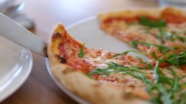 Strachatella peynirli jambonlu pizza, domates ve roka yapraklı. Tahta masada dönüyor. Yüksek kalite 4k görüntü