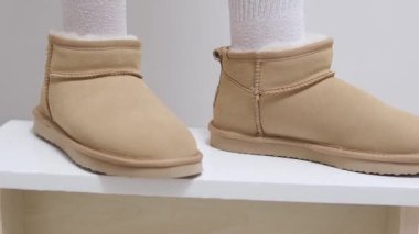 Kadın elleriyle yeni kış ayakkabıları giyer. Yüksek kalite 4k görüntü