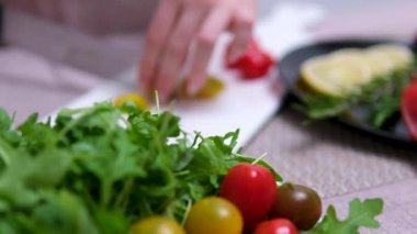 Dikey görüntüler, taze salata üzerine kaşık, roka, somon balığı ve yeşil arka planda domates ile ekleniyor. Yüksek kalite 4k görüntü