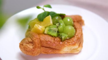 Kivi üzümlü pastalar portakallı mango parçaları ve nane şekerli puf böreği. Yüksek kalite 4k görüntü