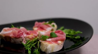 Prosciutto arugula toast poached egg, prosciutto, cream cheese, salad mix and microgreens on a plate. Healthy snack for breakfast. . High quality 4k footage