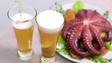 Bira ahtapot salatası deniz ürünleri ile lezzetli soslu ahtapot midyesi yemeyi deneyin, aynı anda büyük bir ahşap tabakta yer alan yiyecekleri paylaşın. Mükemmel ilişkiler. Yüksek kalite 4k görüntü
