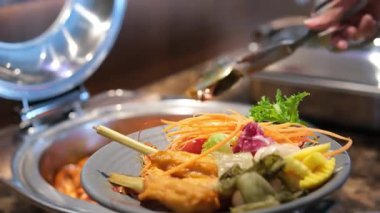 Sıkıştırılmış pirinç kekleri, baharatlı sambal sosu, fıstık sosu ve salata ile bir tabak tavuklu satayın düz bir fotoğrafı. Yüksek kalite 4k görüntü