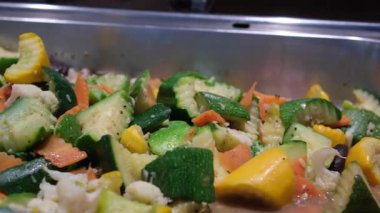 Kazanda kızaran et ve sebzeleri karıştıran kaymağın yakın çekimi. Aşağıdan buhar yükseliyor. Kafkas ya da Asya mutfağı. Seçici odaklanma. Yüksek kalite 4k görüntü