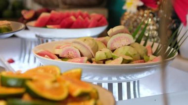 Karpuz, mango, papaya ve ananas da dahil olmak üzere taze dilimlenmiş tropikal meyveler tabakta, sağlıklı beslenme ve yaz içeceğini betimliyor. Sağlıklı beslenme ve yaşam tarzı. 4k