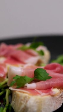 Prosciutto roka tostu haşlanmış yumurta, prosciutto, krem peynir, salata karışımı ve bir tabakta mikroyeşillik. Kahvaltı için sağlıklı atıştırmalıklar. - Evet. Yüksek kalite 4k görüntü