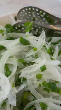 Beyaz mutfak tahtasında büyük bir bıçakla beyaz soğan. Yavaş çekim 100 fp. Yüksek kalite 4k görüntü